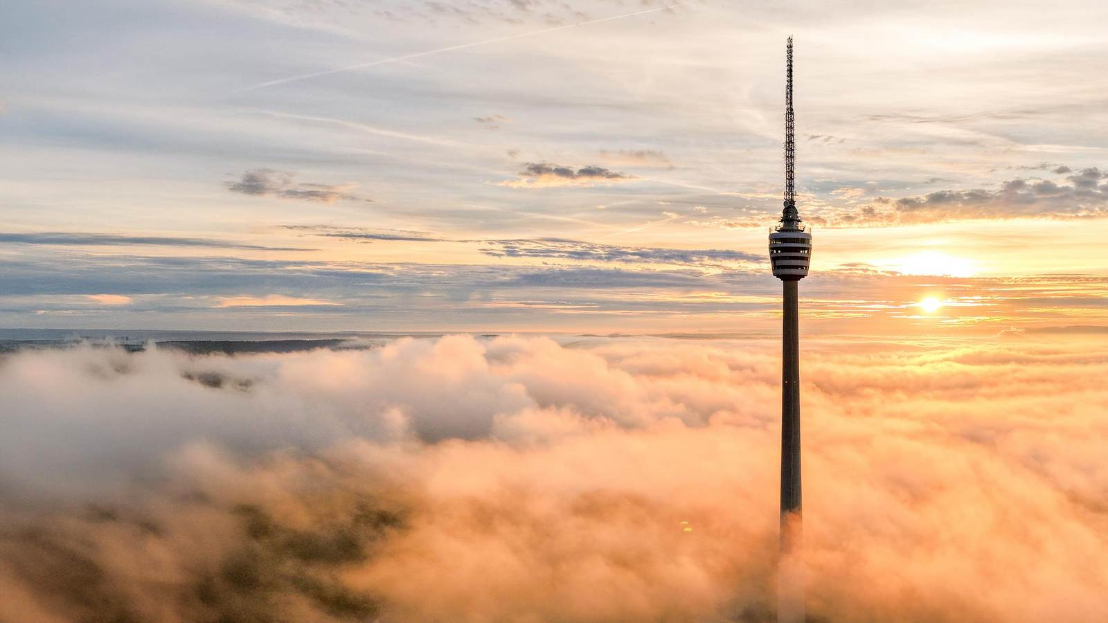 Stuttgarter Fernsehturm in den Wolken bei Sonnenaufgang